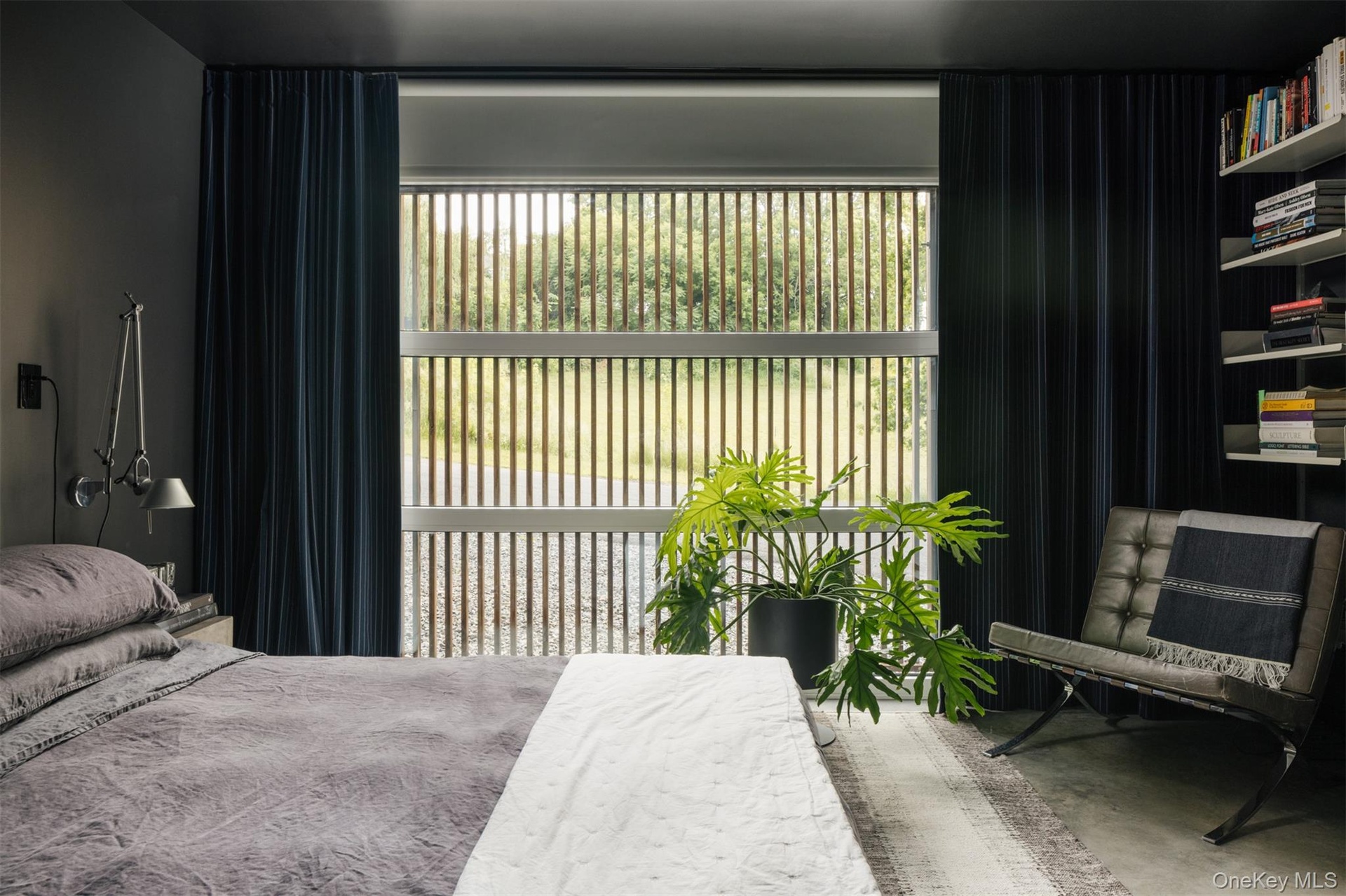 Bedroom featuring concrete flooring and multiple windows