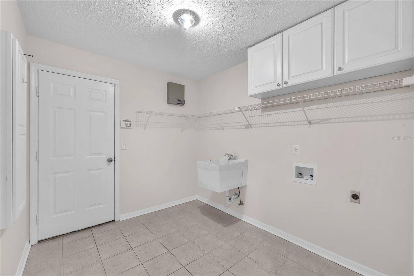 A spacious laundry room with a convenient utility sink adds functionality to everyday living.