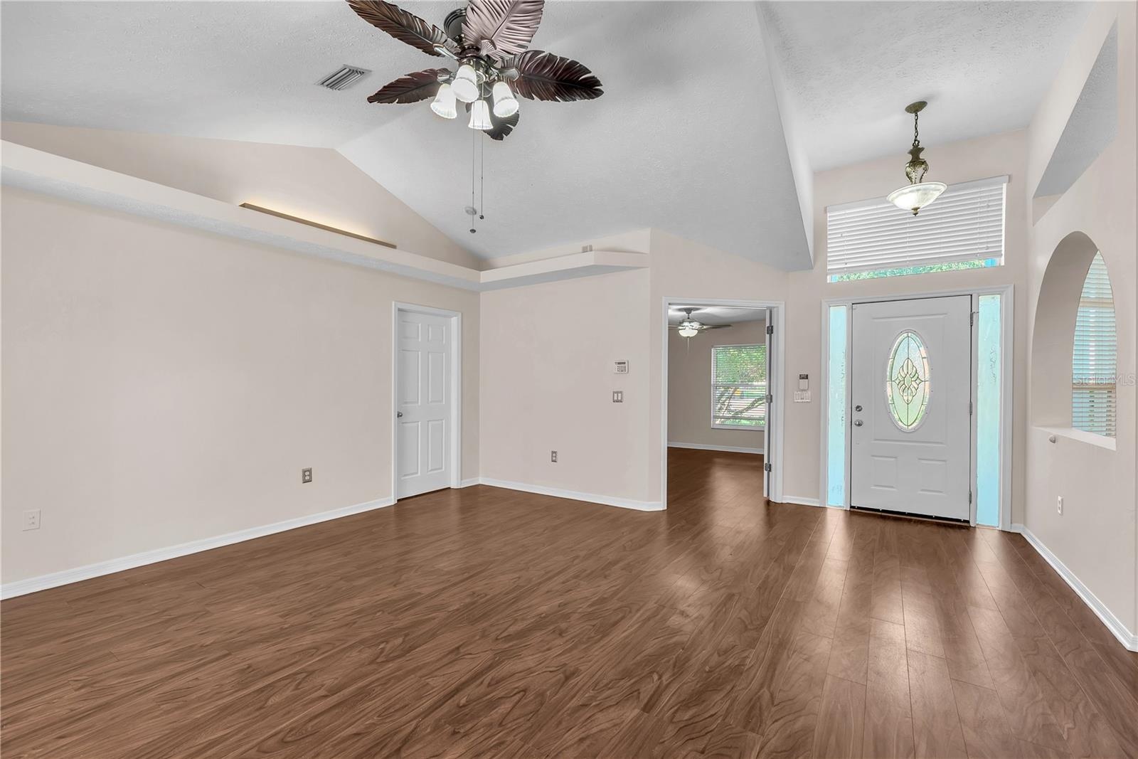 The elegant front entry features a decorative leaded-glass oval door flanked by two sidelights and topped with a transom window, allowing beautiful na