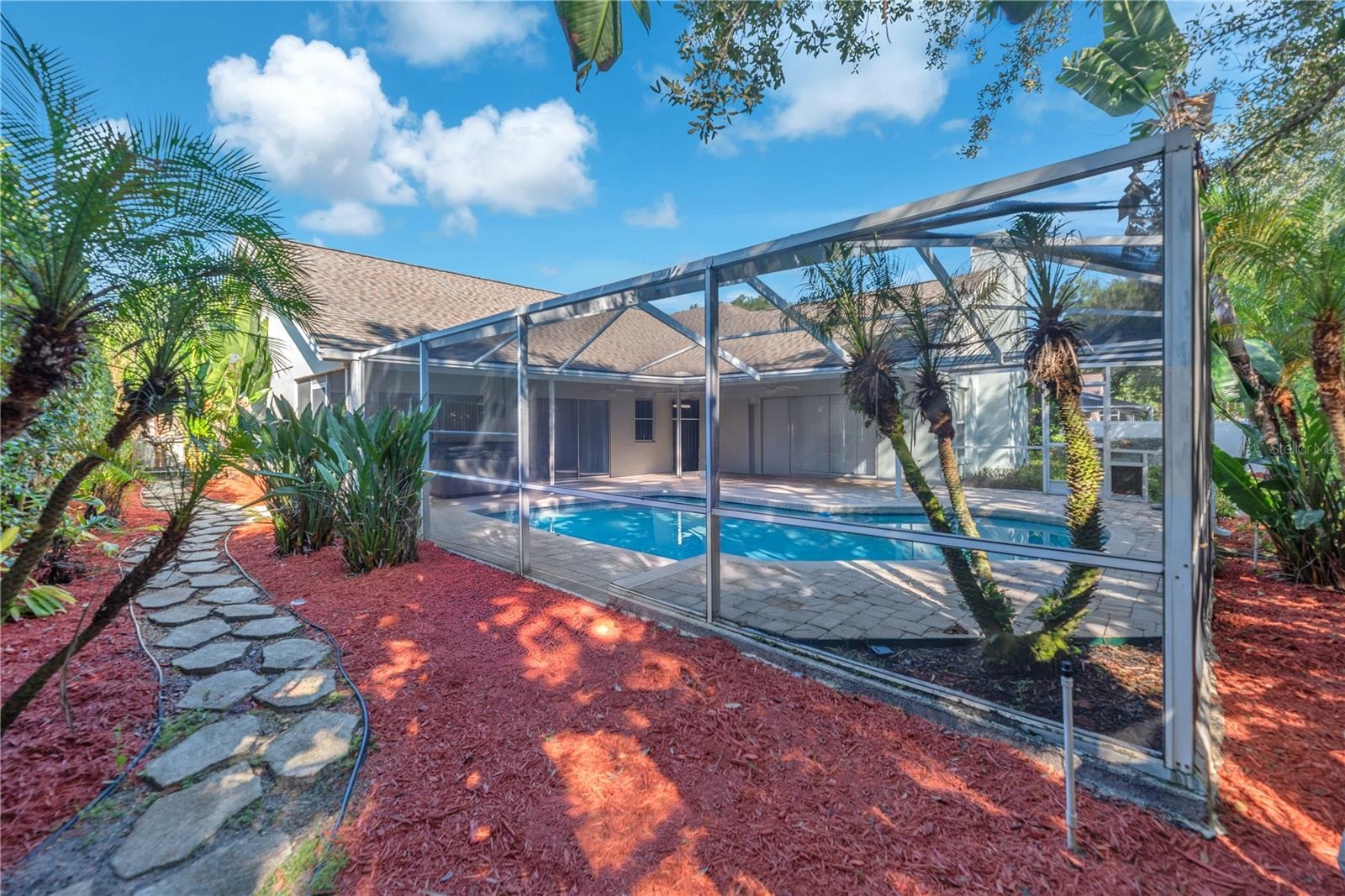 The backyard pool area is very private and landscaping is lush and tropical.