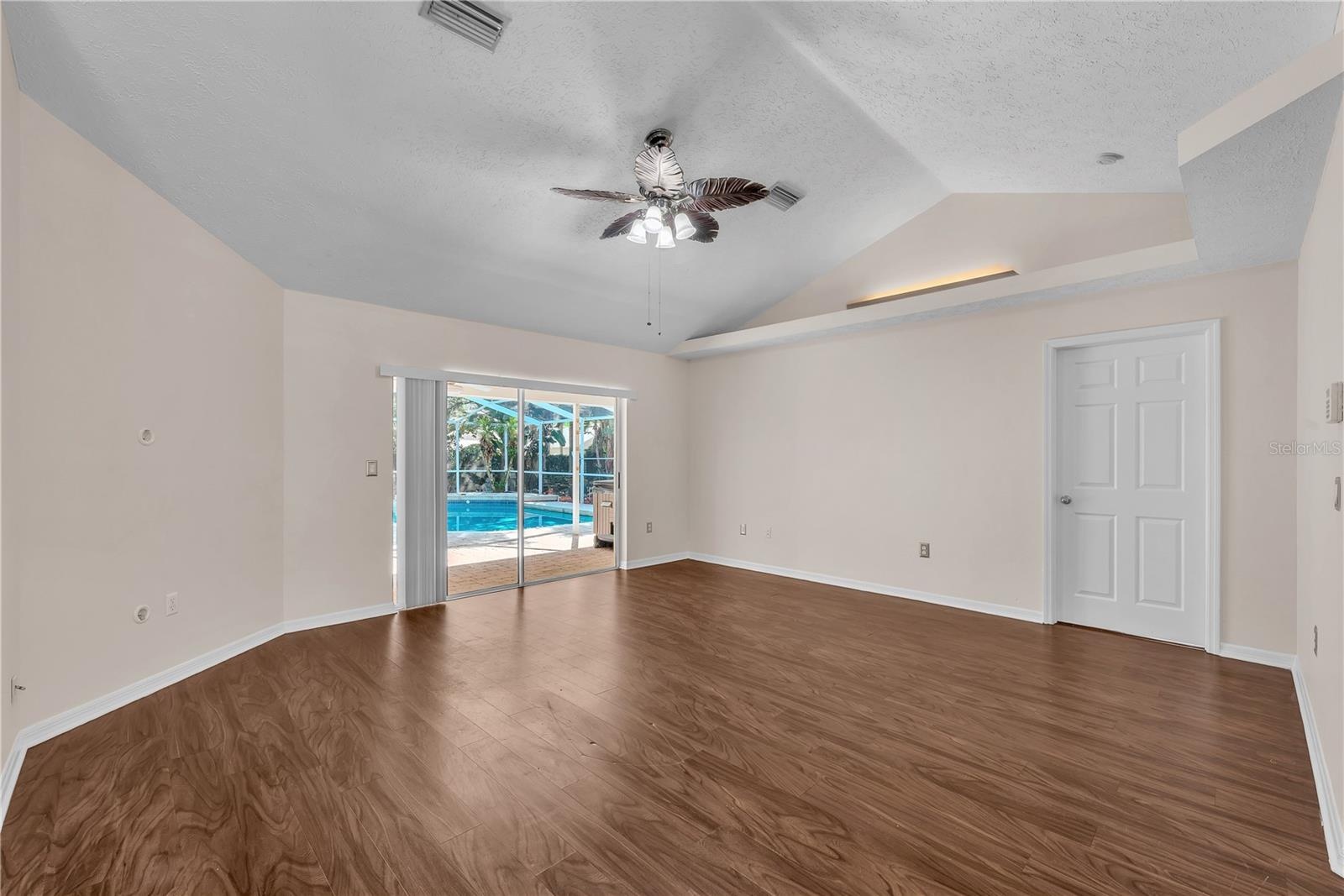 As you enter the living room, your eye is naturally drawn through the space to the sparkling pool and inviting backyard beyond, creating an immediate 