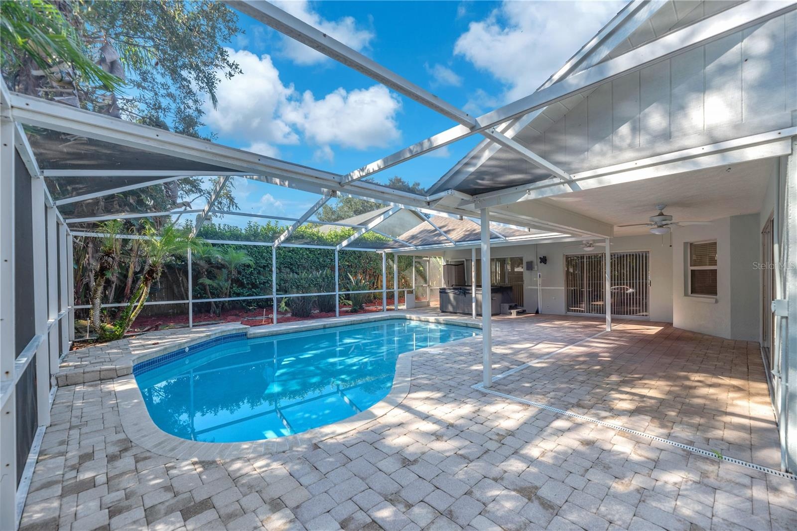 Step outside to your own backyard retreat, where the spacious screened lanai surrounds a sparkling pool and spa accented by elegant pavers.