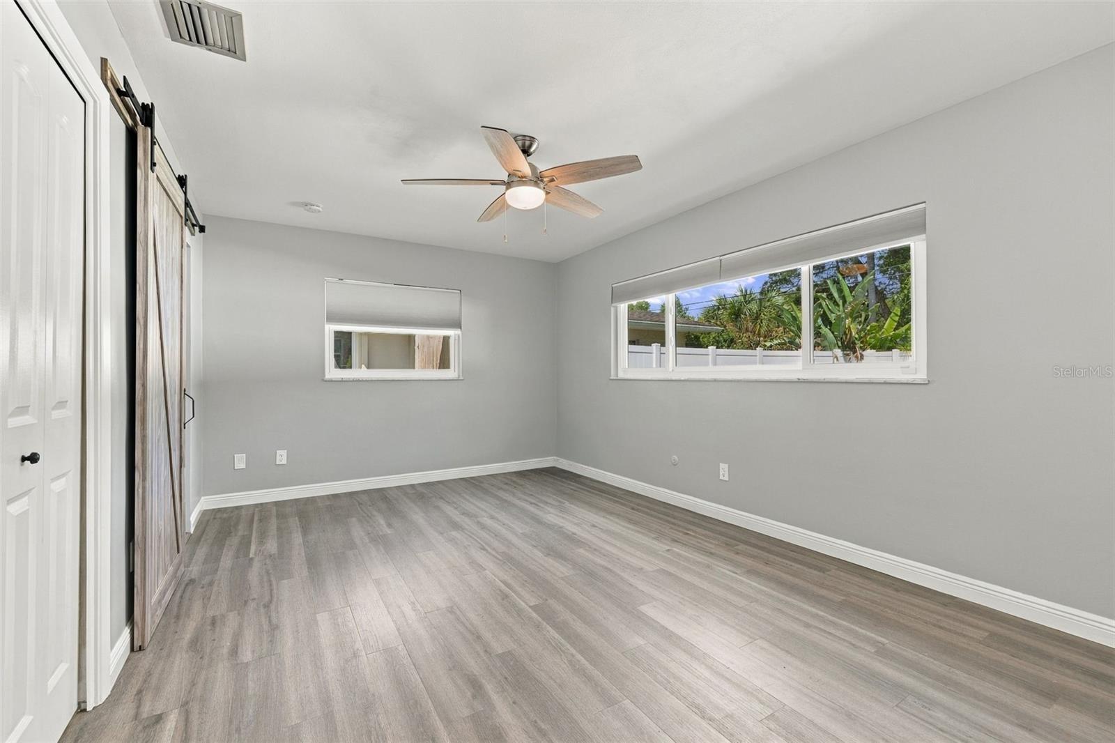 The primary bedroom has a walk-in closet and barn door to the ensuite bathroom.