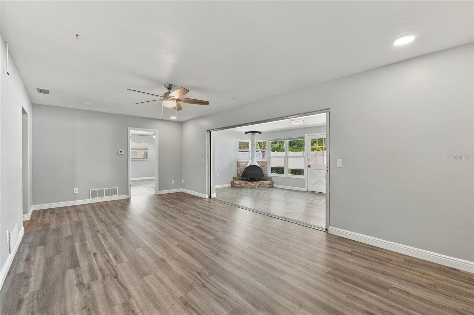 This large room off the kitchen also opens up to the Florida room and fireplace. The door on the far wall is to the primary bedroom and ensuite bathro