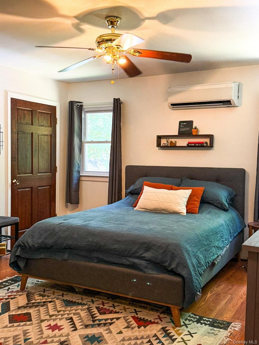 Upper Apartment  Bedroom with Hardwood-style flooring and his and her closets