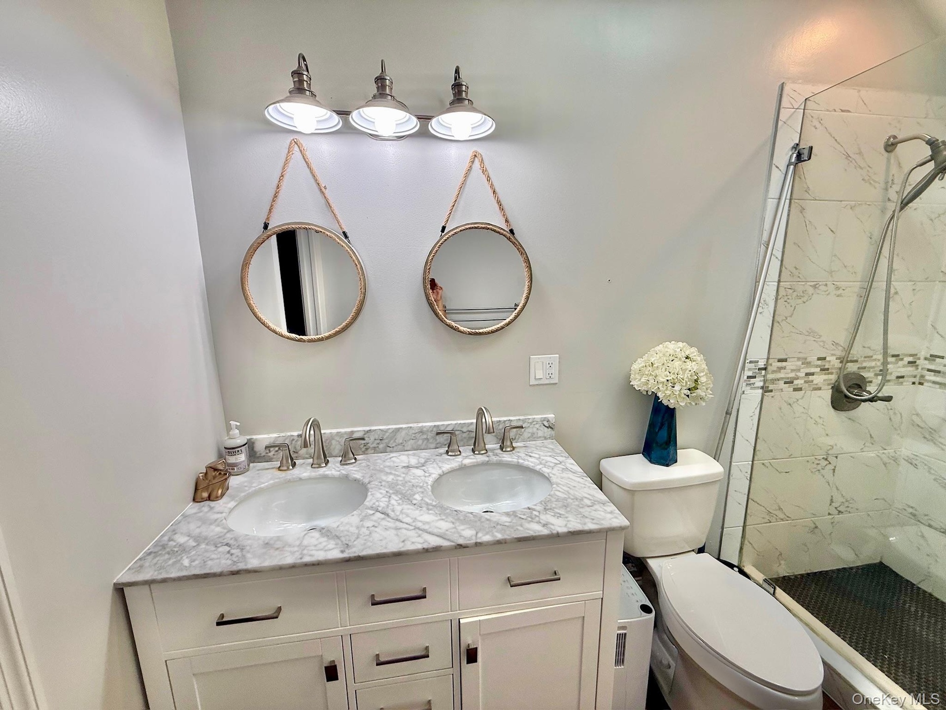 Cottage In The Back Bathroom Dual vanity with stone countertop, undermount sinks, and brushed nickel fixtures