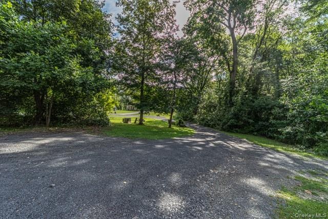 Gravel driveway with abundant mature trees and natural landscaping