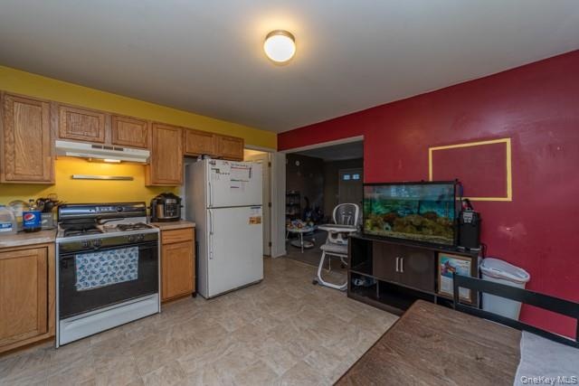 Kitchen with wood cabinetry, laminate countertops, and a white refrigerator