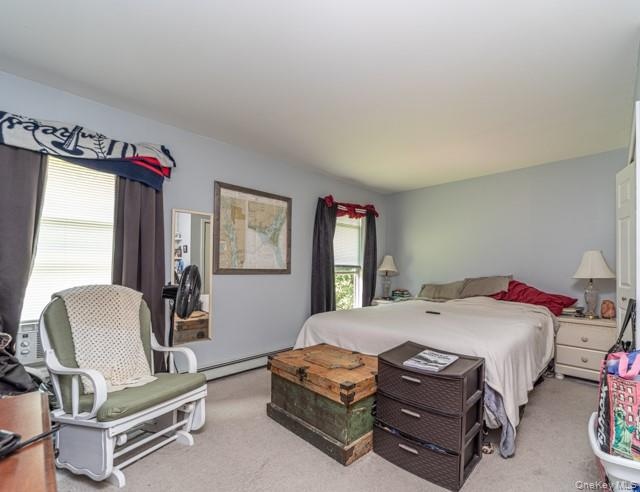 Carpeted room featuring light blue walls, two windows with blinds, and white trim