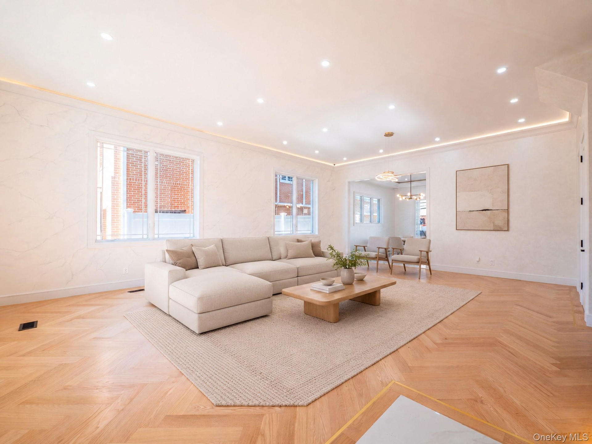 Herringbone wood-finish flooring, recessed ceiling lighting, cove lighting, and a wide cased opening