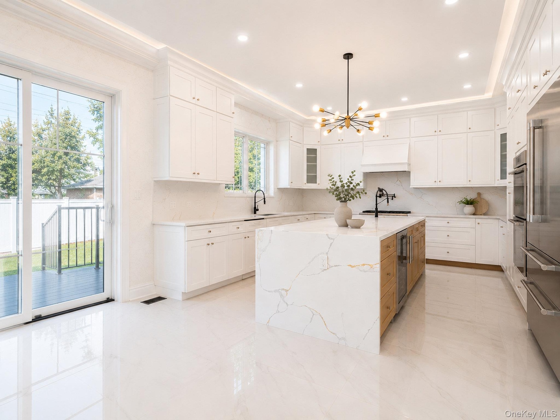 Gleaming tile flooring, white shaker cabinetry, and a waterfall island with stone countertop