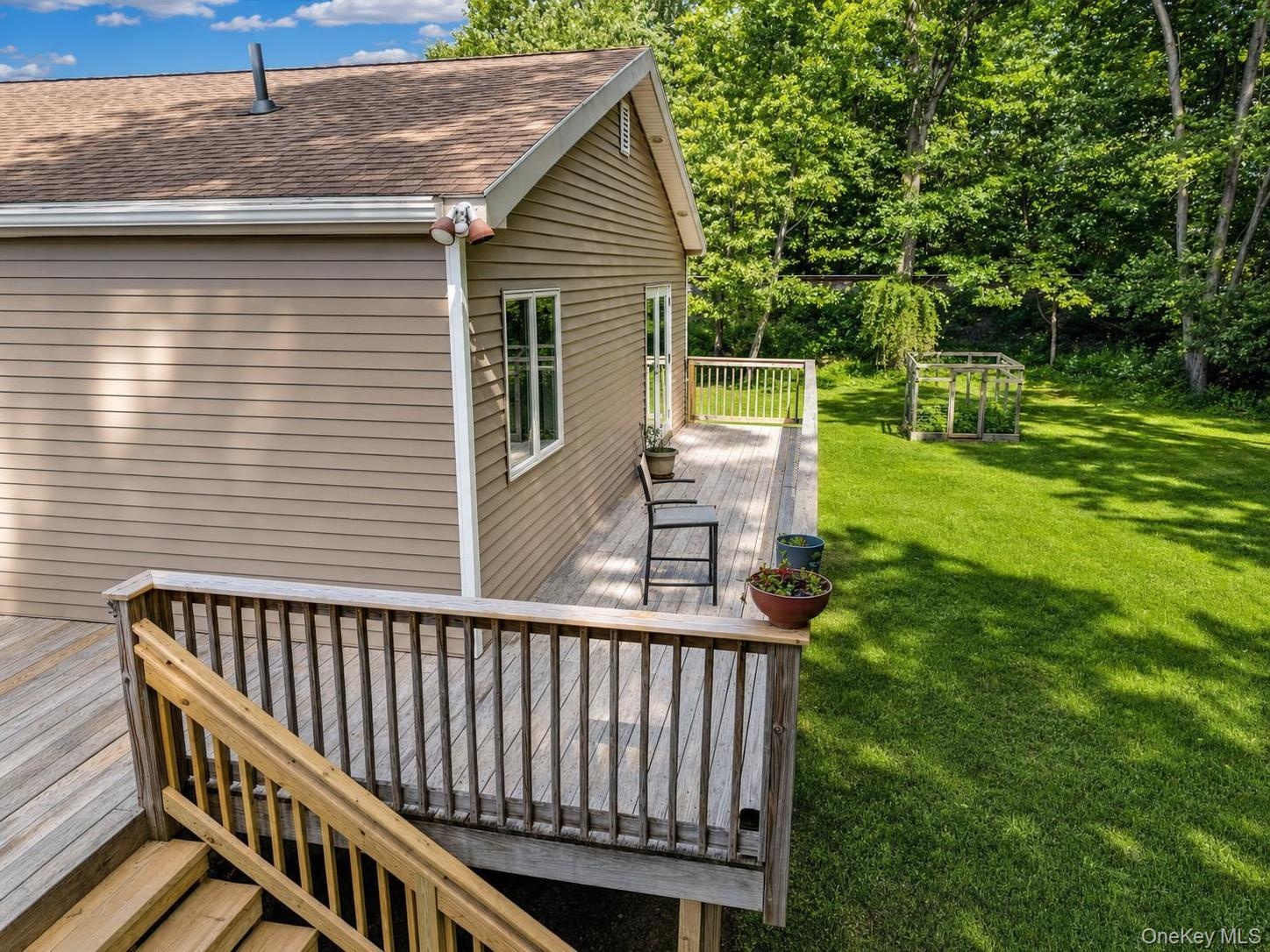 Spacious rear deck featuring natural wood decking and railings