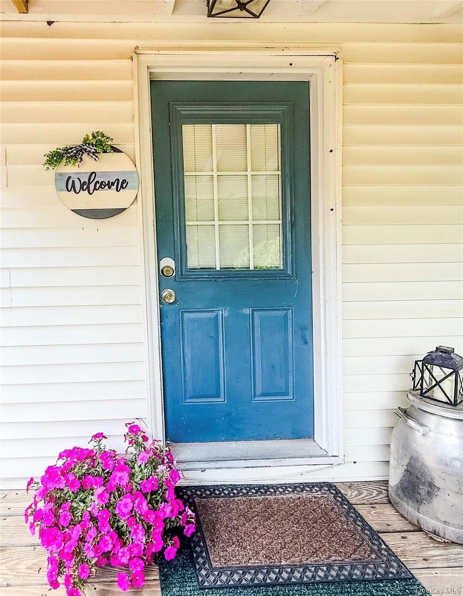 Lower apartment of two story structure in back of main house. with blue door and glass paneling