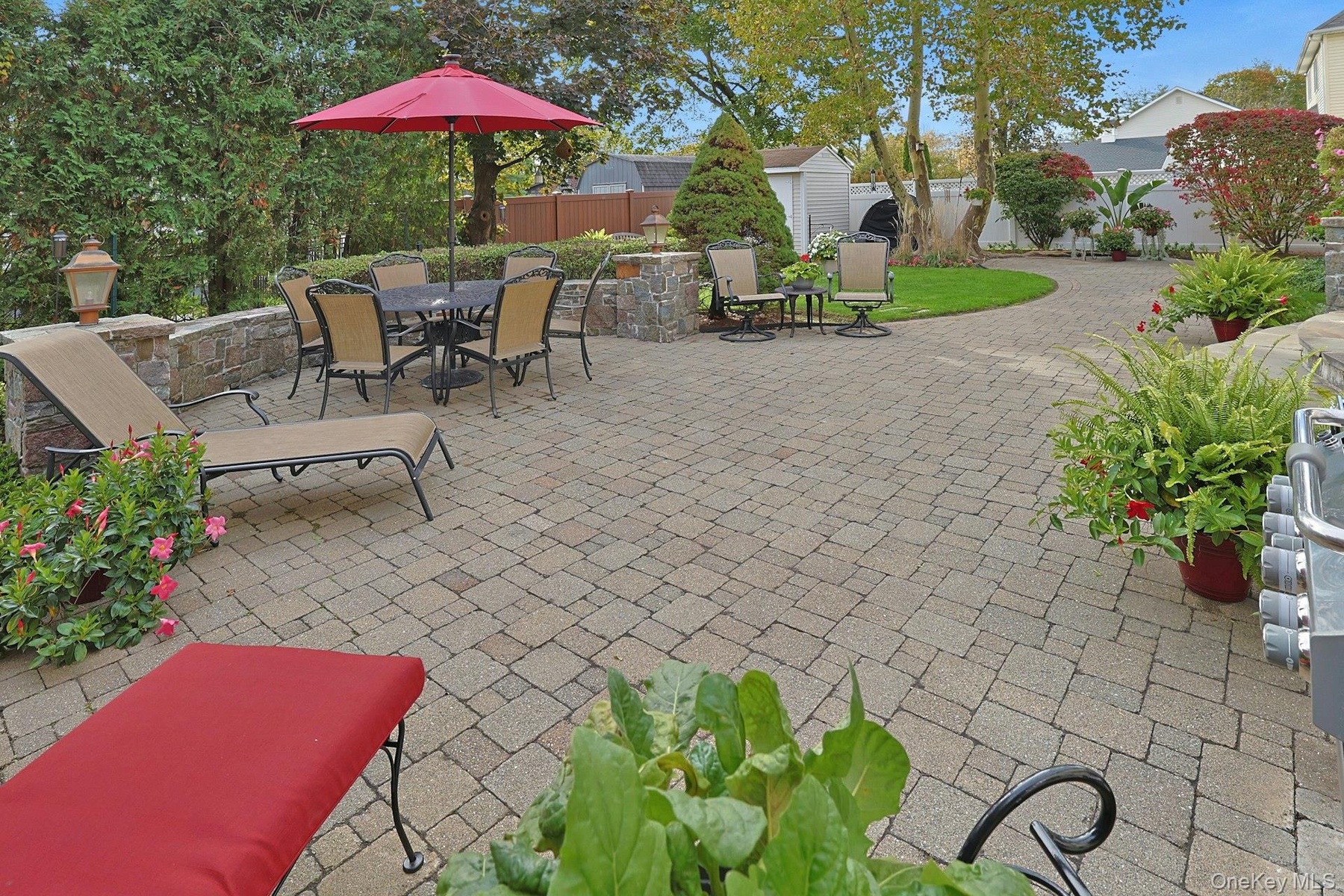 Paver Patio With Granite Stone Sitting Wall and Coach Lanterns