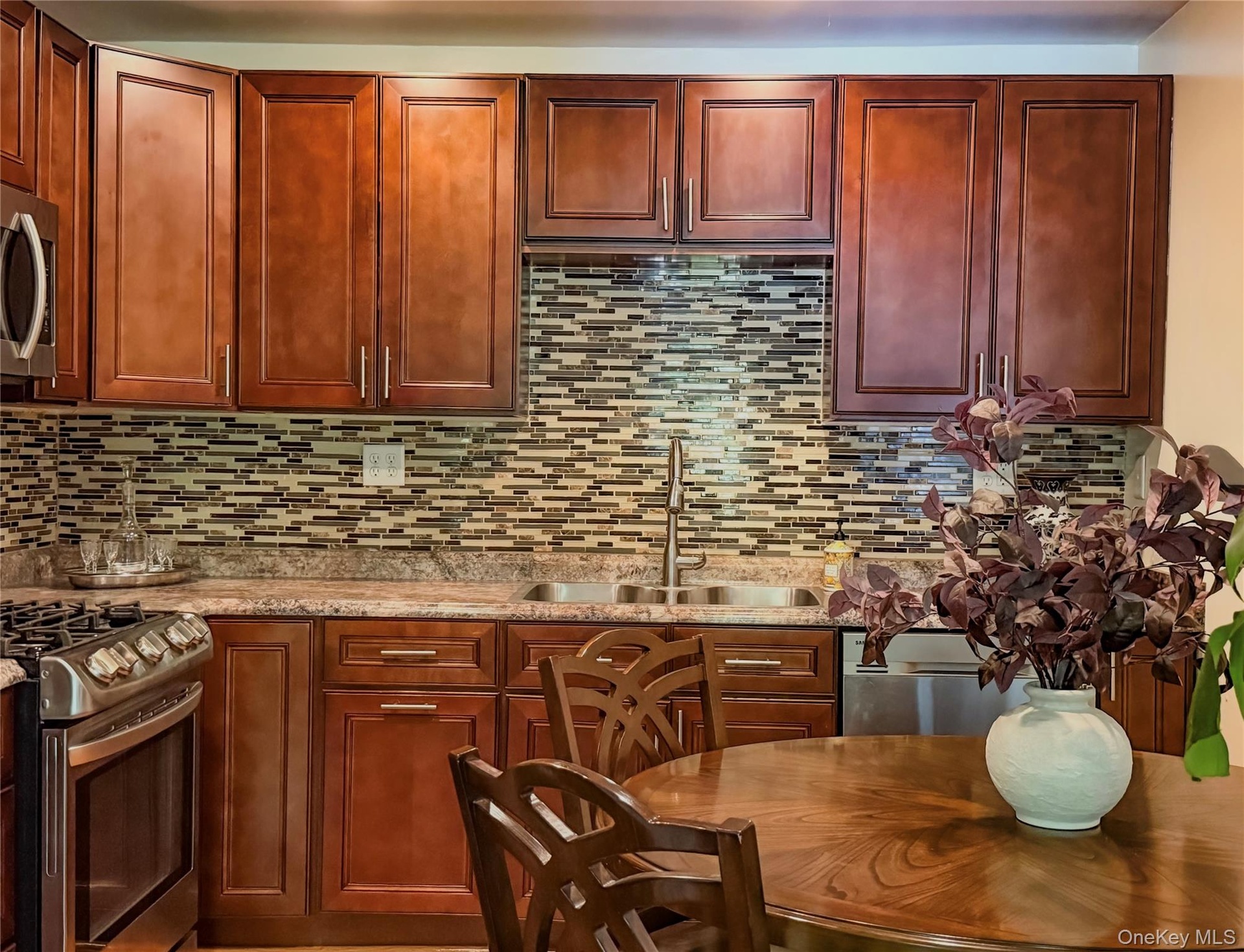 Lower Apartment Kitchen featuring wood-finish cabinetry, stainless steel appliances, eat-in kitchen area