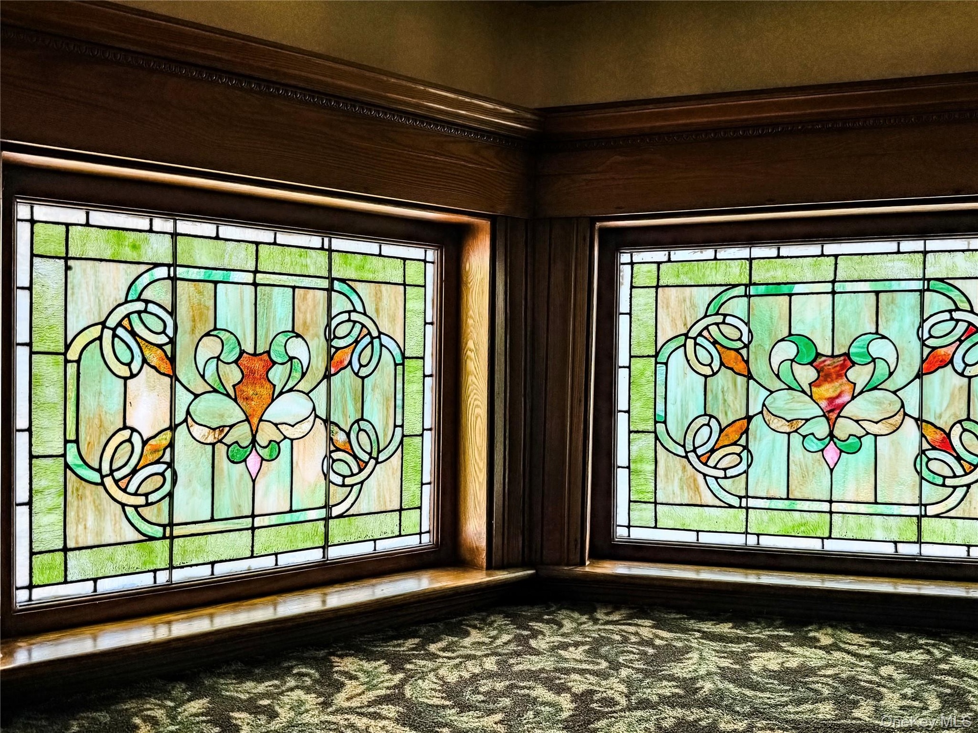 Three Story Stair Well Stained glass windows with intricate patterns, framed by rich wood millwork and crown molding