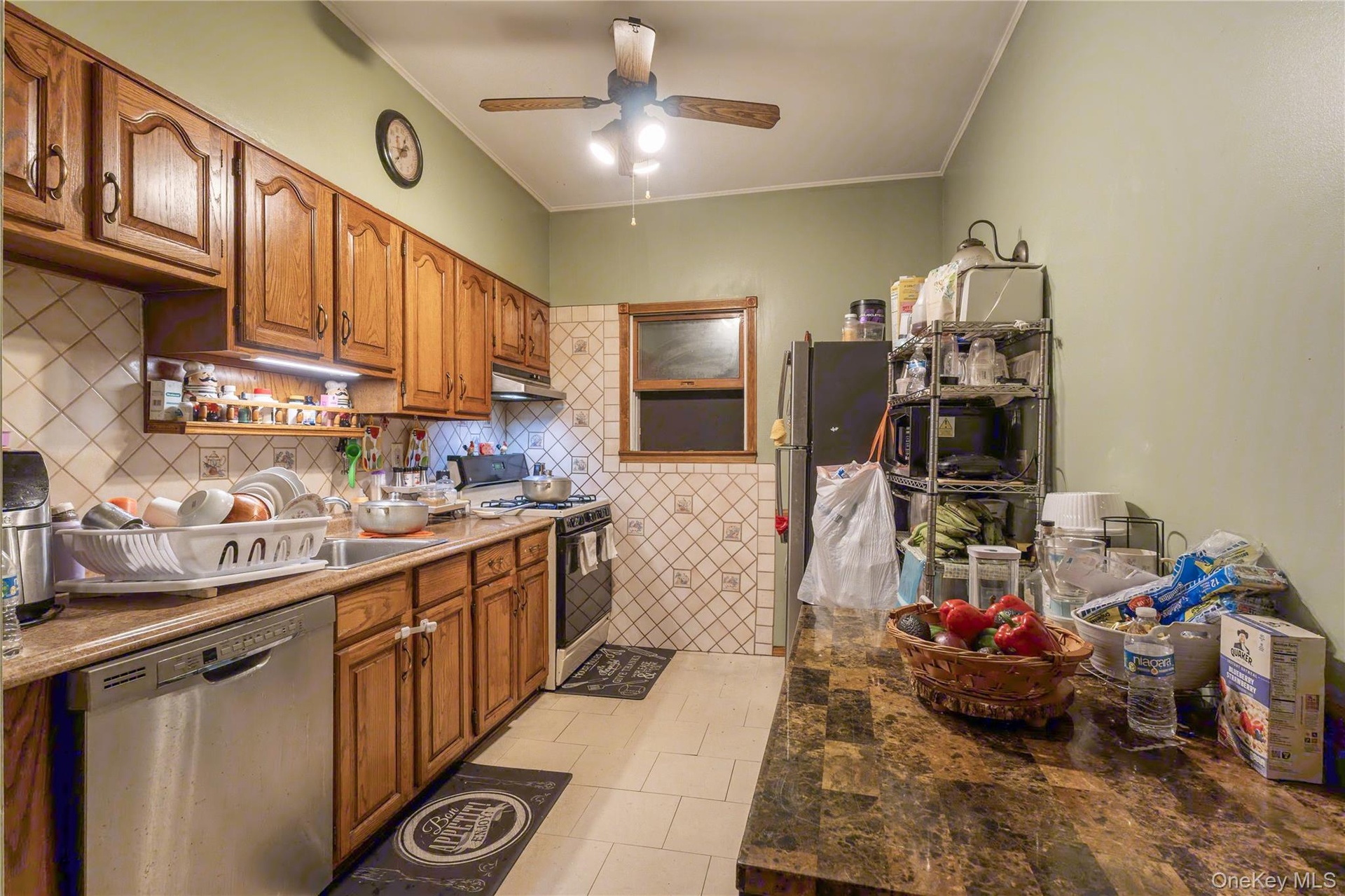 Wood-finish cabinetry paired with a refrigerator, gas range, and dishwasher.
