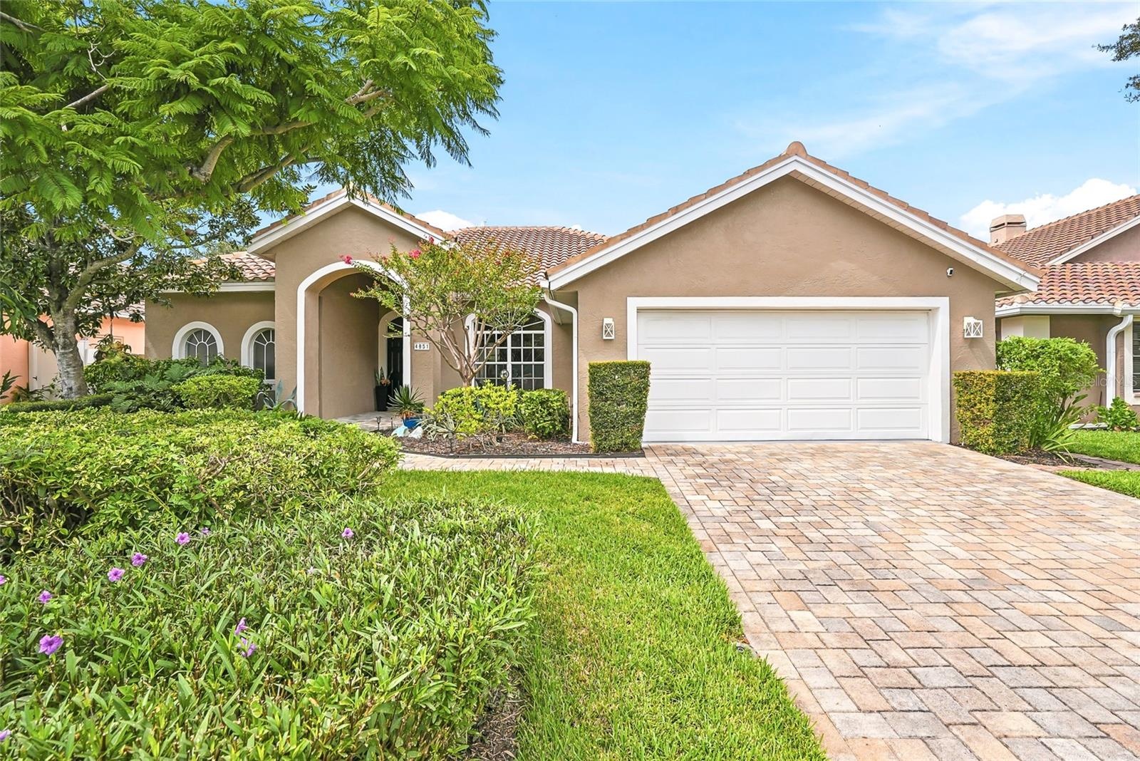 Artisan-pavers and lush landscaping greet you upon arriving at this stunning single-level home.