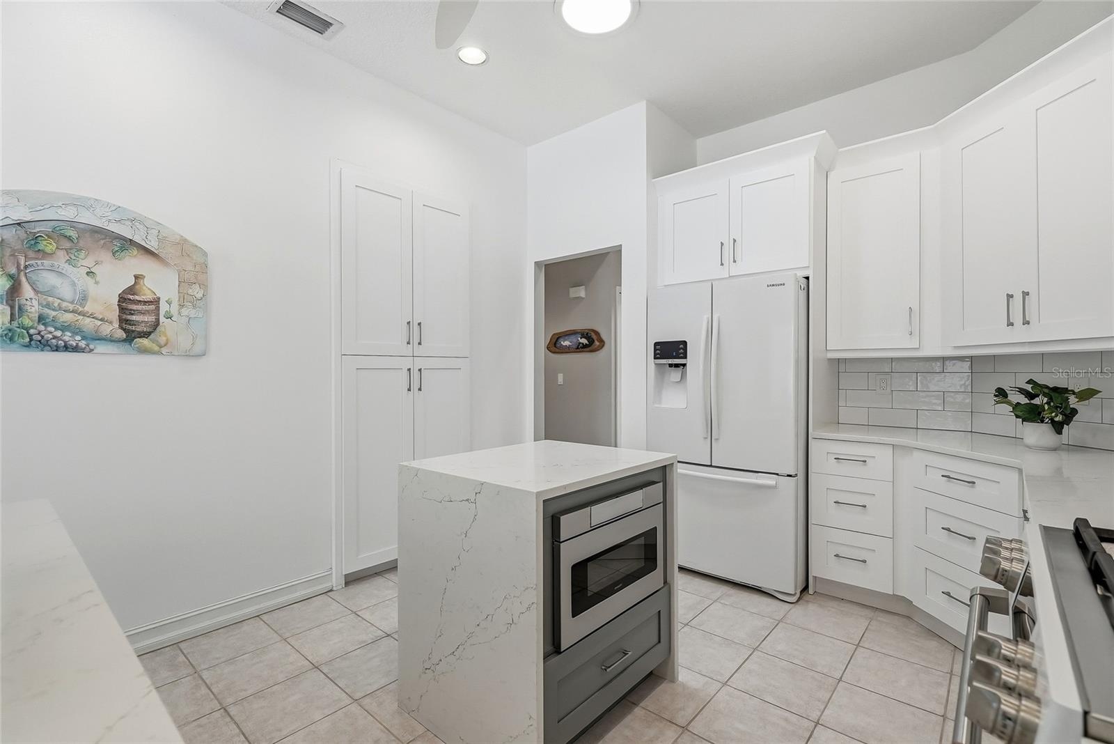Discreet microwave in the kitchen island keeps the streamlined look of the kitchen.