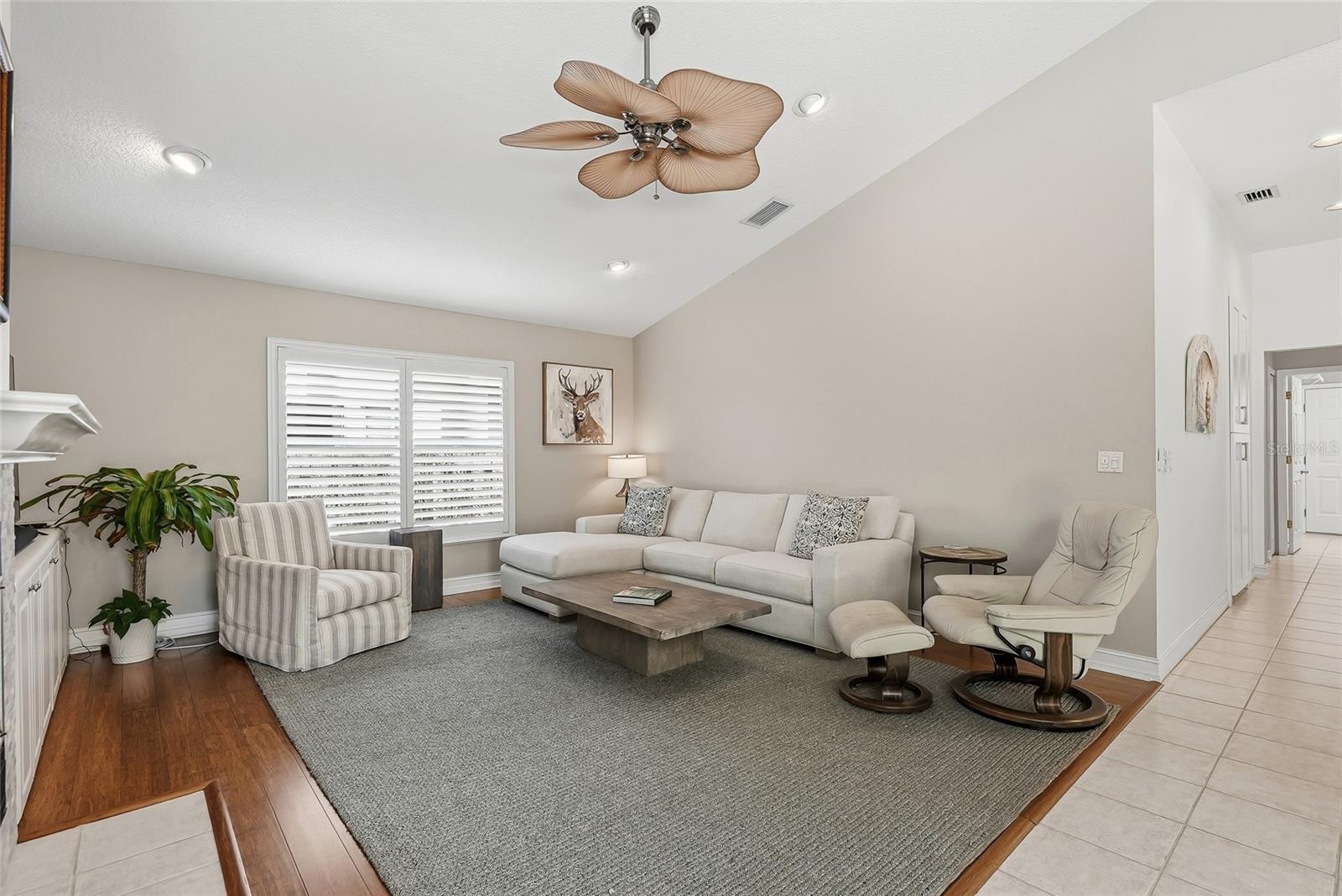 Large living room with media built ins and a wood-burning fireplace.