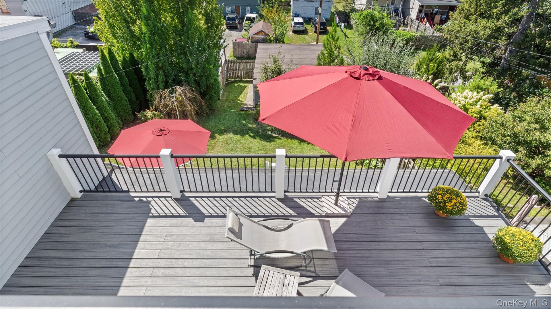 View down to private balcony off second floor primary suite and the deck on the first floor off the kitchen,