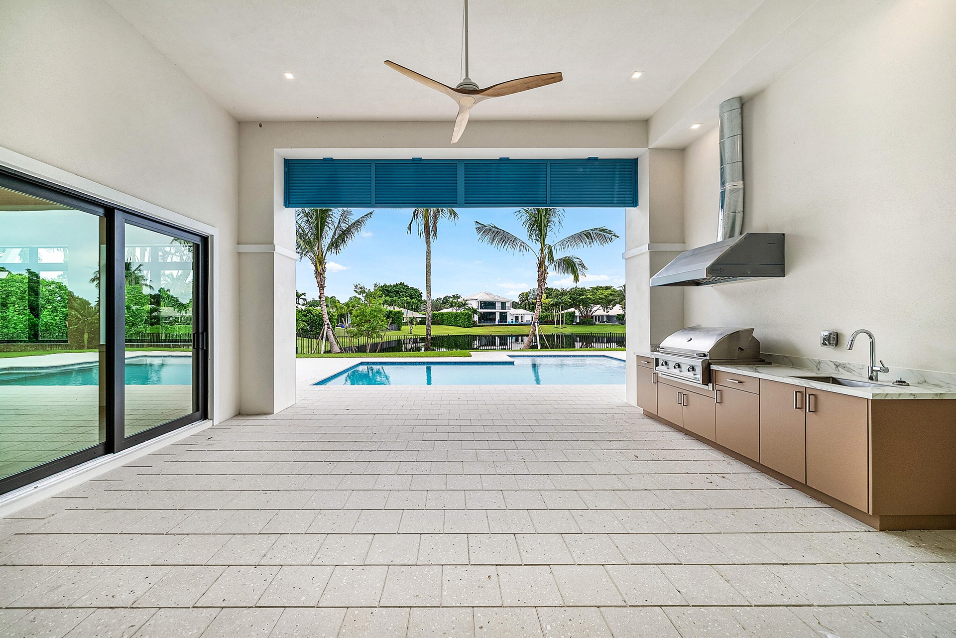 Covered loggia with an Outdoor Kitchen overlooking the pool and lake.