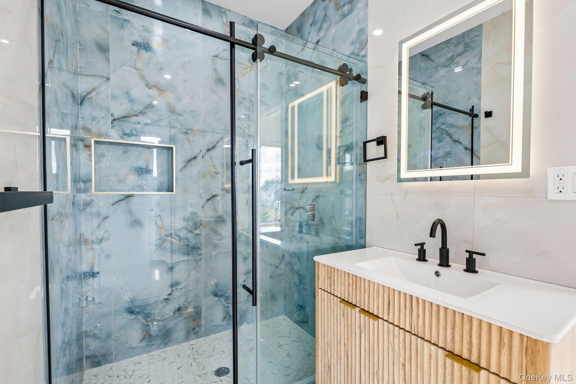 Shower with blue marble-effect tile and sliding glass door