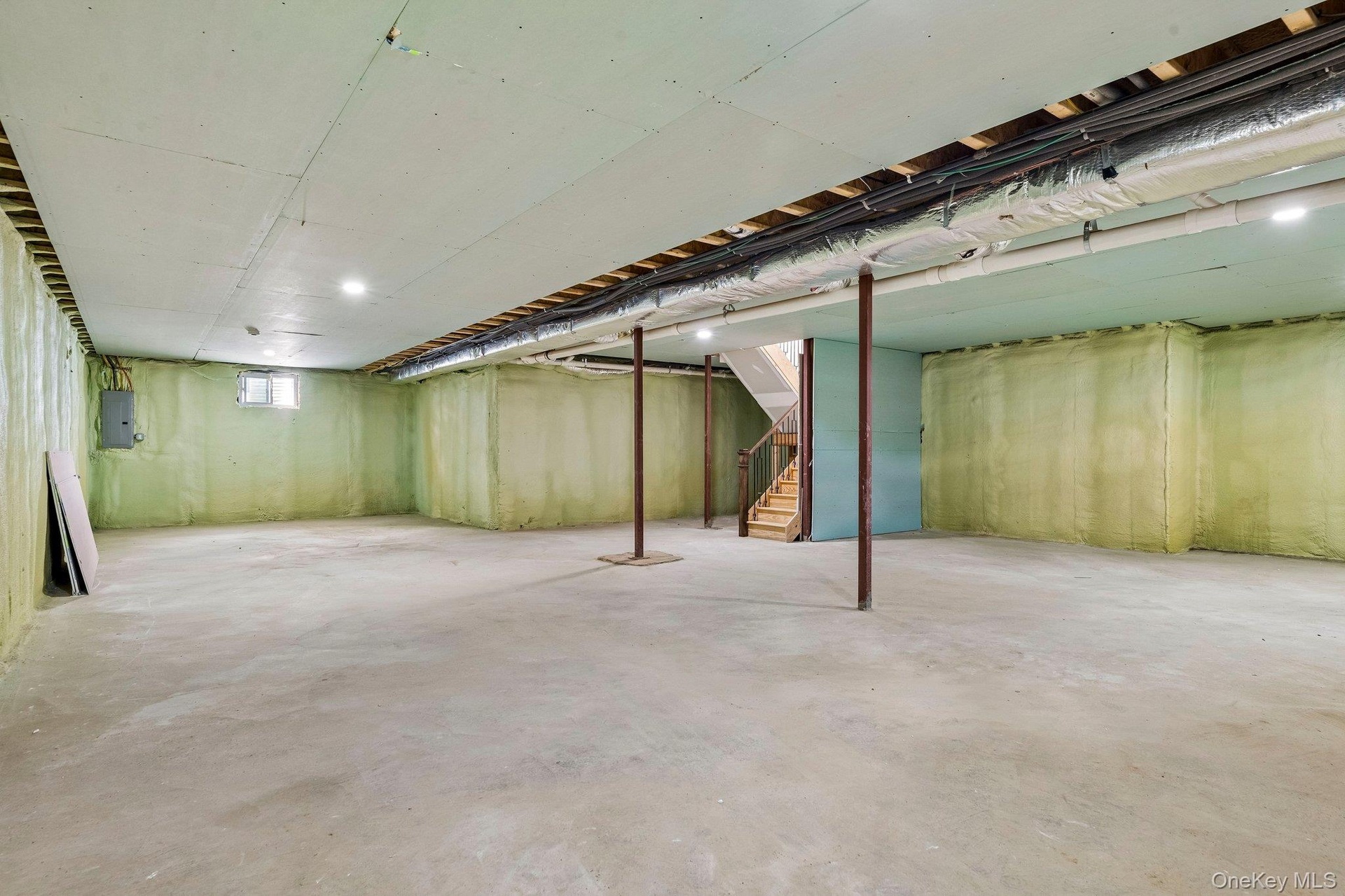 Spacious unfinished lower level with concrete flooring, recessed lighting, exposed ceiling joists, and a window