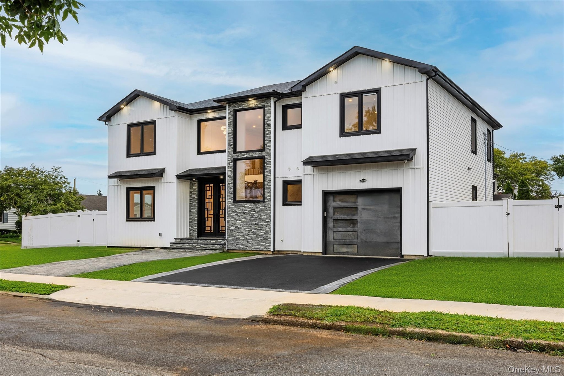Contemporary exterior featuring white vertical siding and dark-trimmed windows