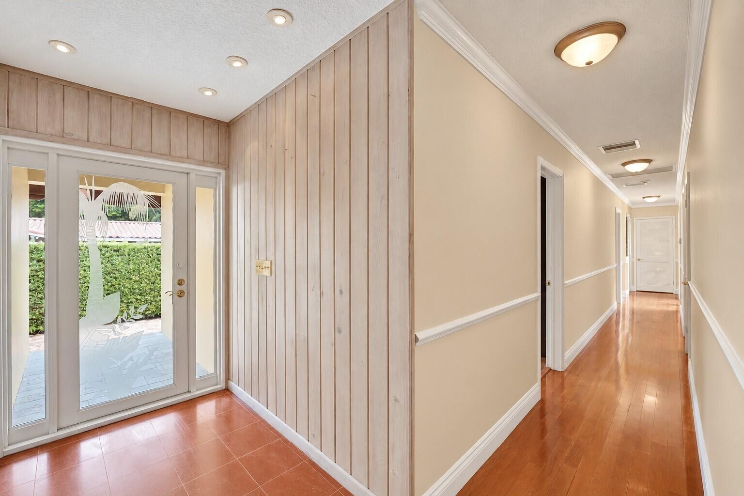 Entryway with recessed lighting, wood plank wall paneling, and a double-door entry with sidelights