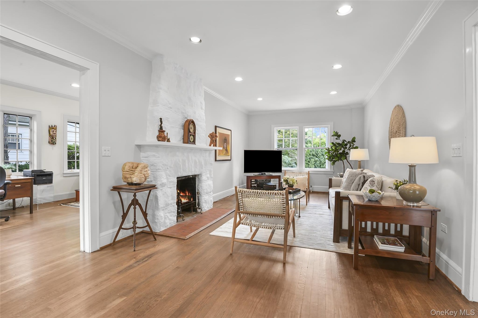 Living room has front to back windows, hardwood flooring and recessed lighting.