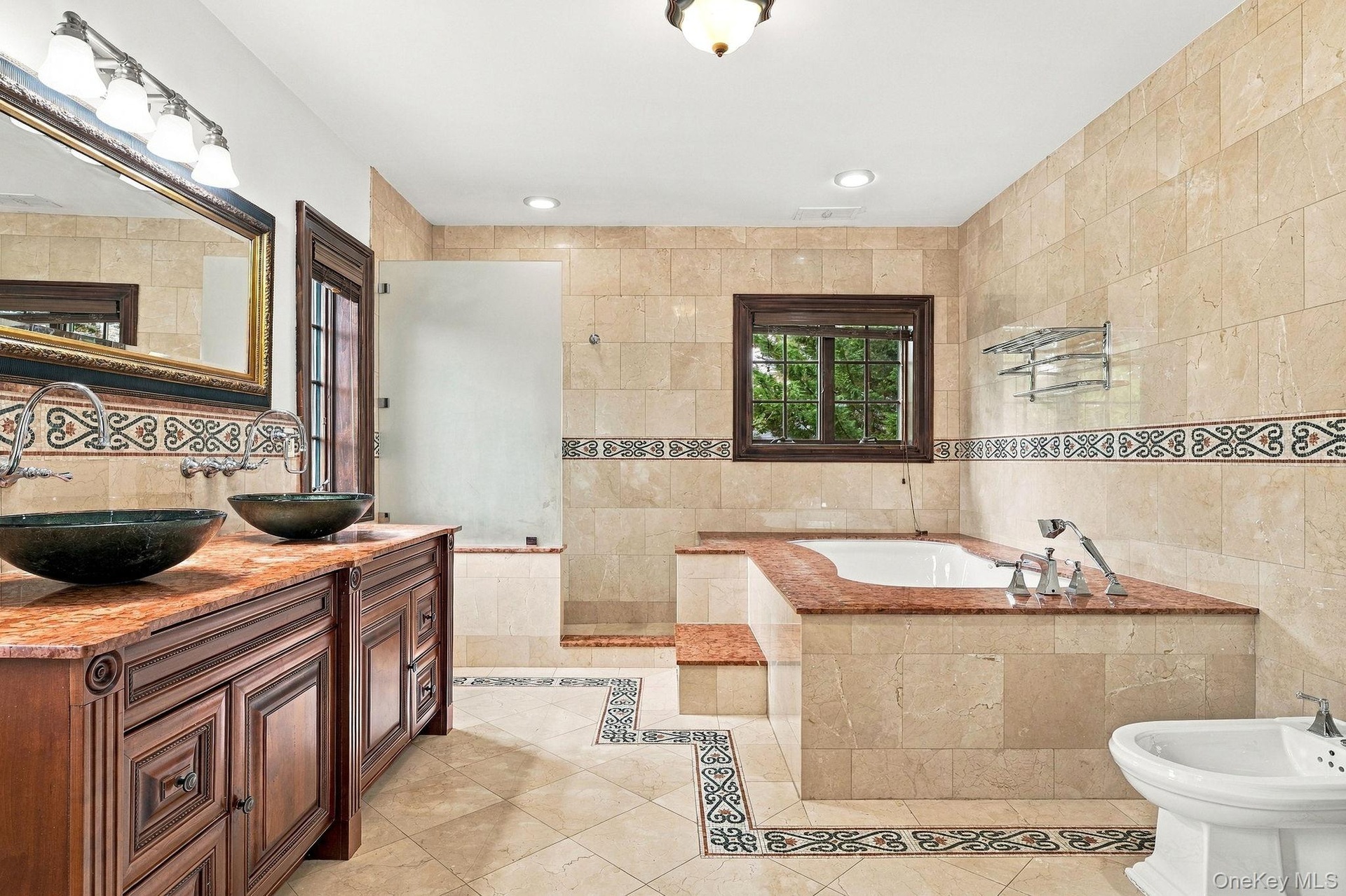 A marble-and-granite bath worthy of the primary suite.