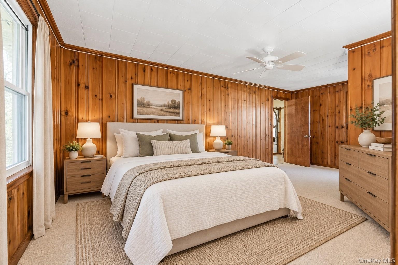 **Virtually Staged** Wood-paneled walls with light-colored carpeting, featuring a ceiling fan and a window with white trim