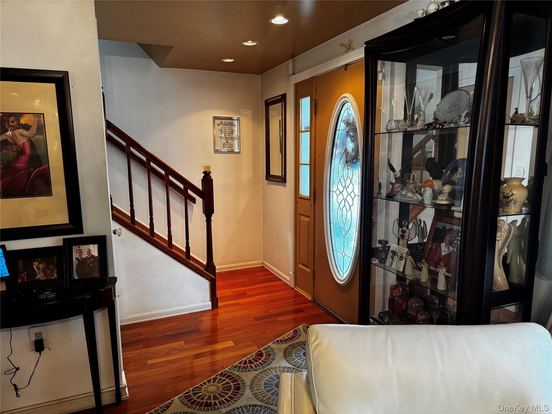 Hardwood flooring, recessed lighting, and a wood staircase with balusters