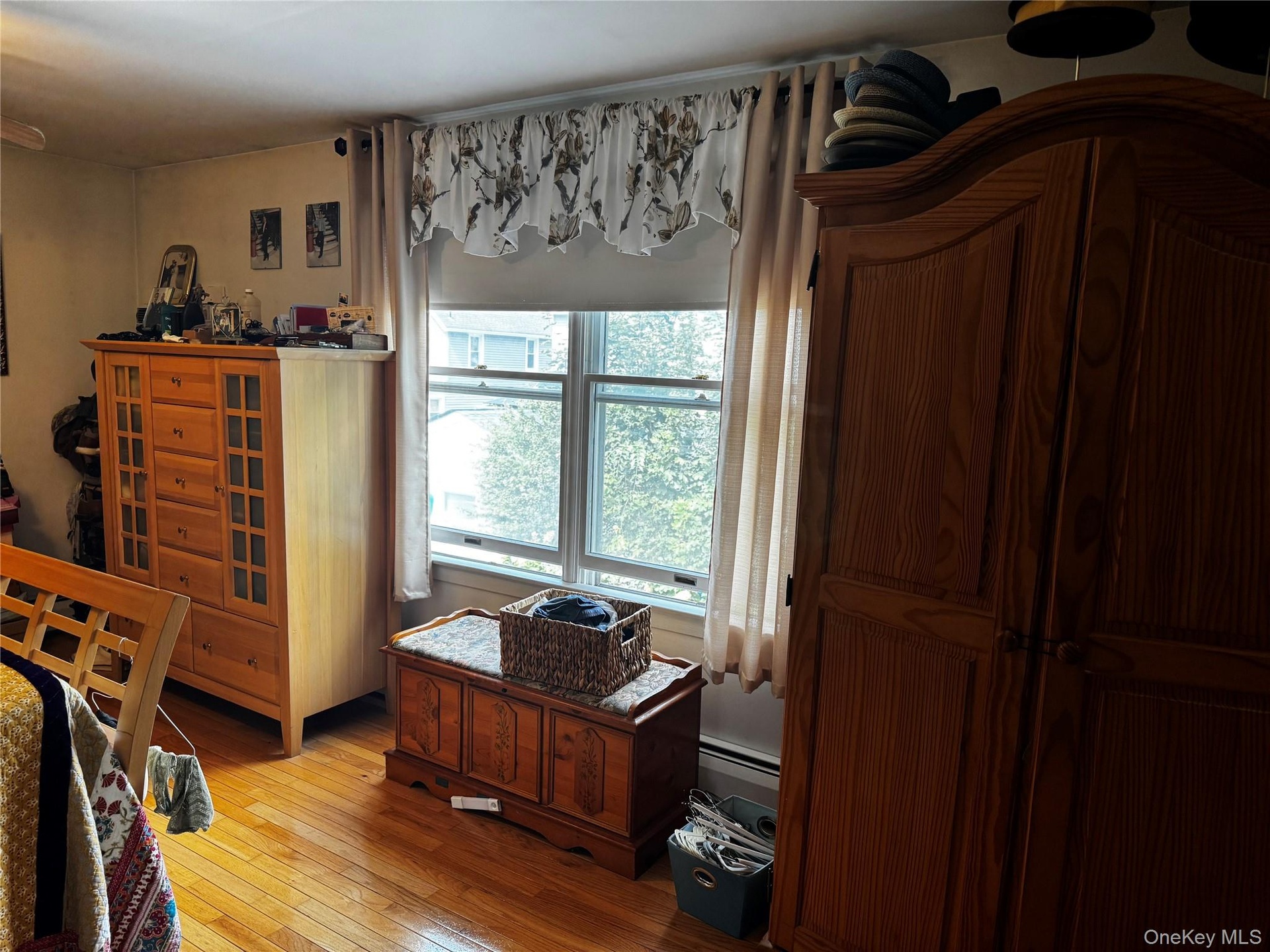 Hardwood flooring, window with sash detail, and baseboard heating