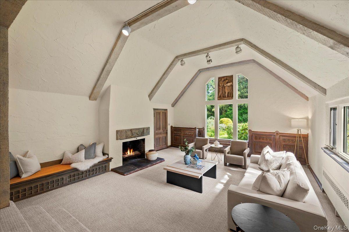 The family room features gorgeous beamed cathedral ceilings with windows overlooking the lush greenery on the back of the property.