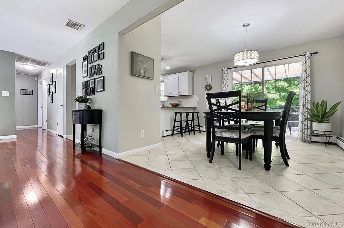 Country kitchen w/sliders to decking!Hardwood-finish flooring, light-toned wall paint, sliding glass door, overhead lighting fixture, and tile floorin
