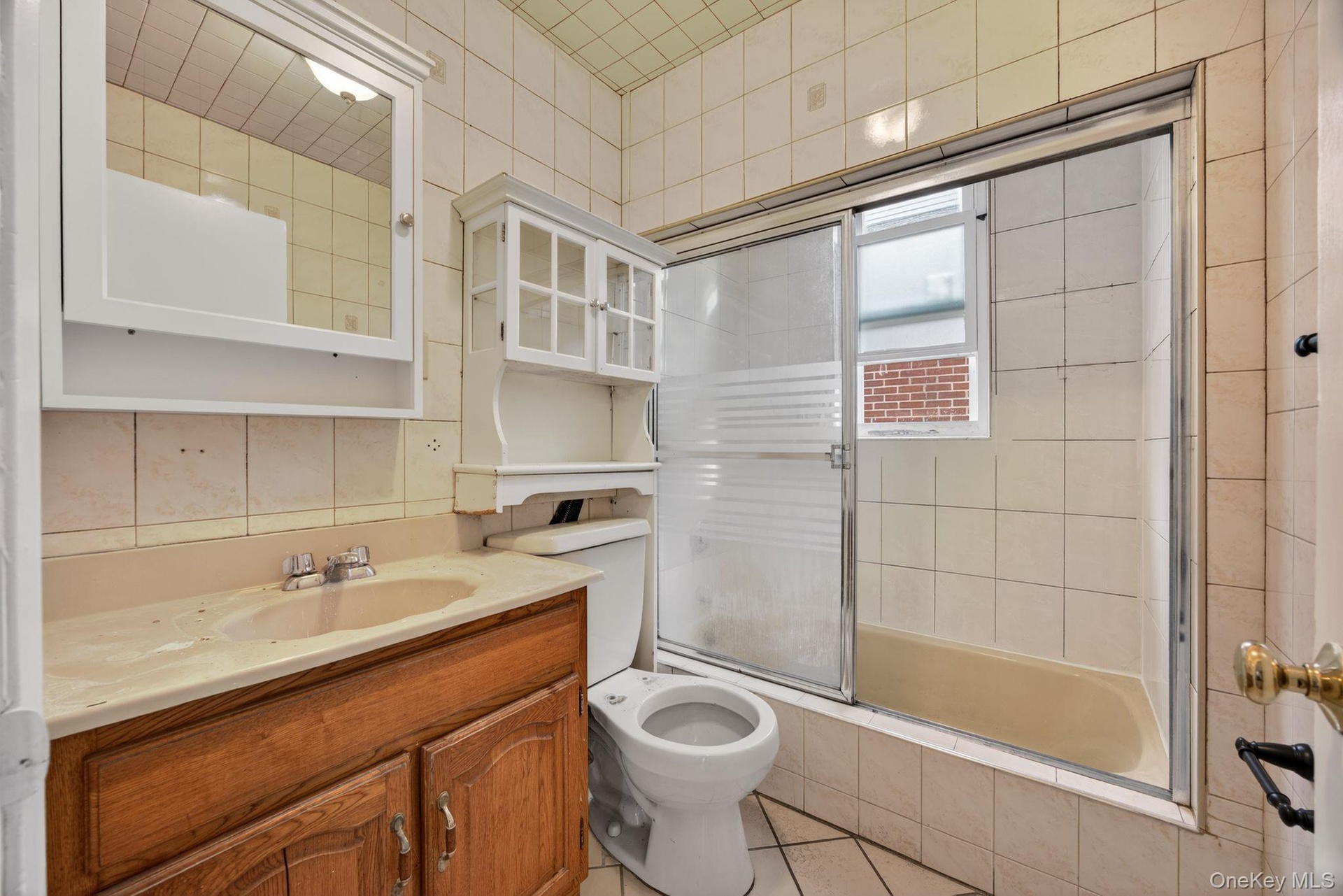 Full bath featuring tiled shower / bath, vanity, and light tile patterned flooring