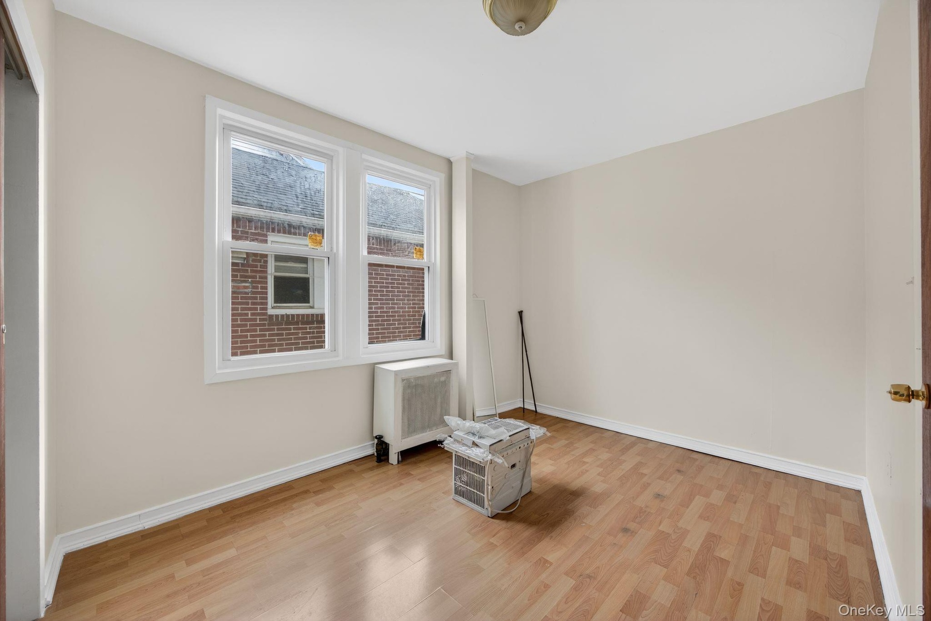 Spare room with radiator heating unit and light wood-style flooring