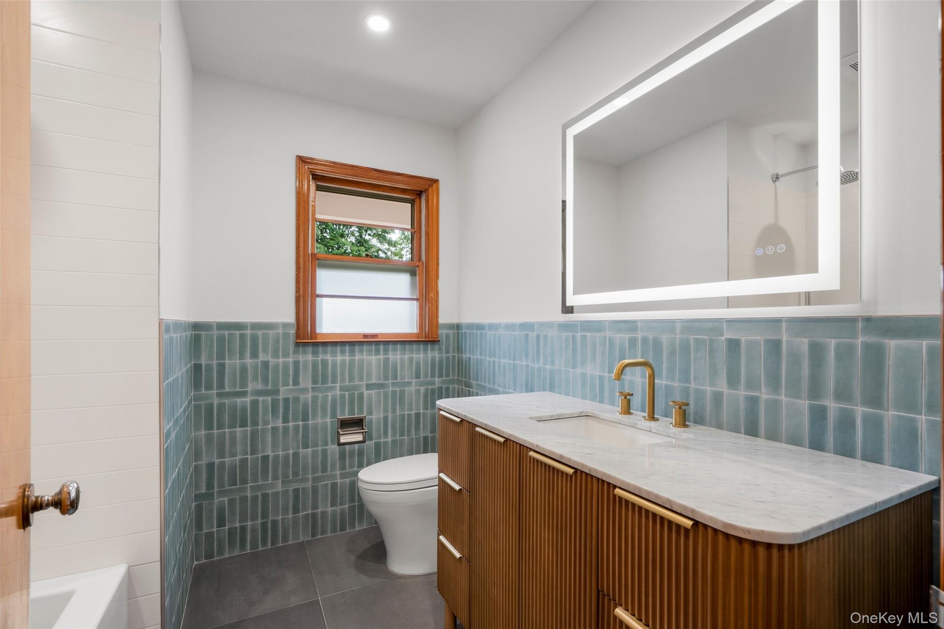 Full bath with tub, glazed tile and fogless mirror