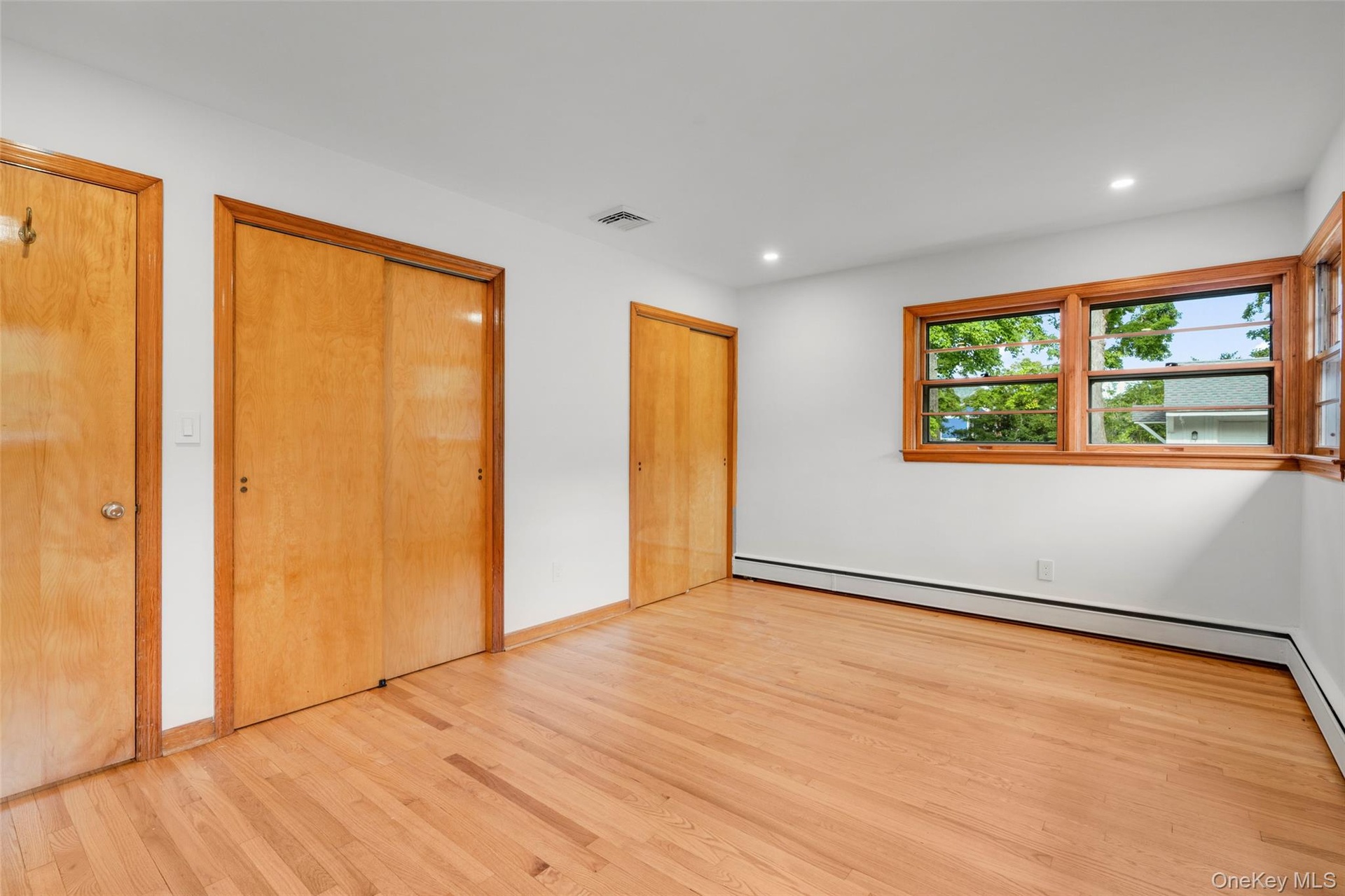 Primary bedroom with two large closets and mid-century window detail