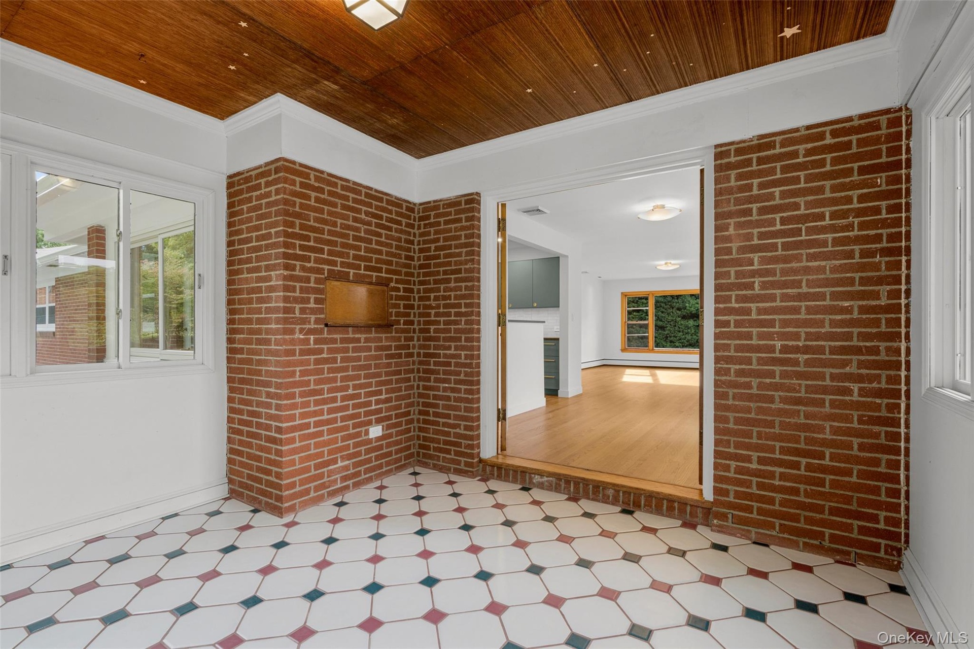 Tiled sunroom with entrance to the dining area
