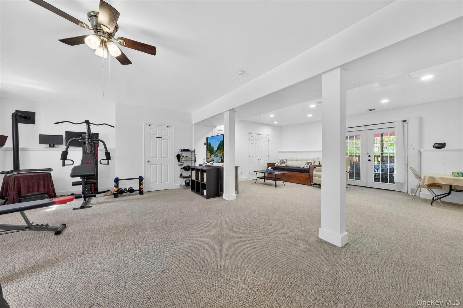 Recessed lighting, ceiling fan, white paneled doors, carpeted flooring, and French doors