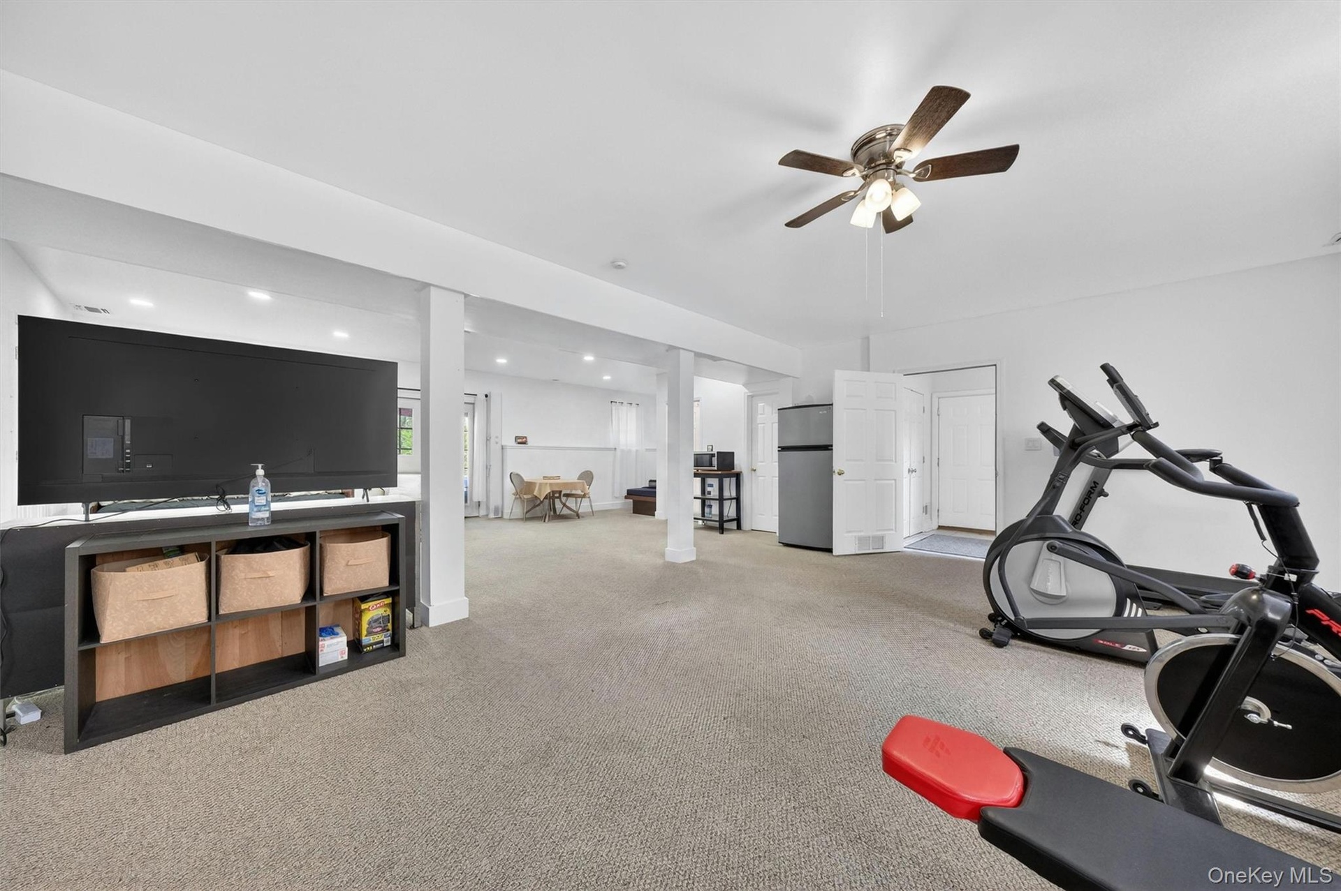 Spacious finished lower level with recessed lighting, carpeted flooring, and a ceiling fan