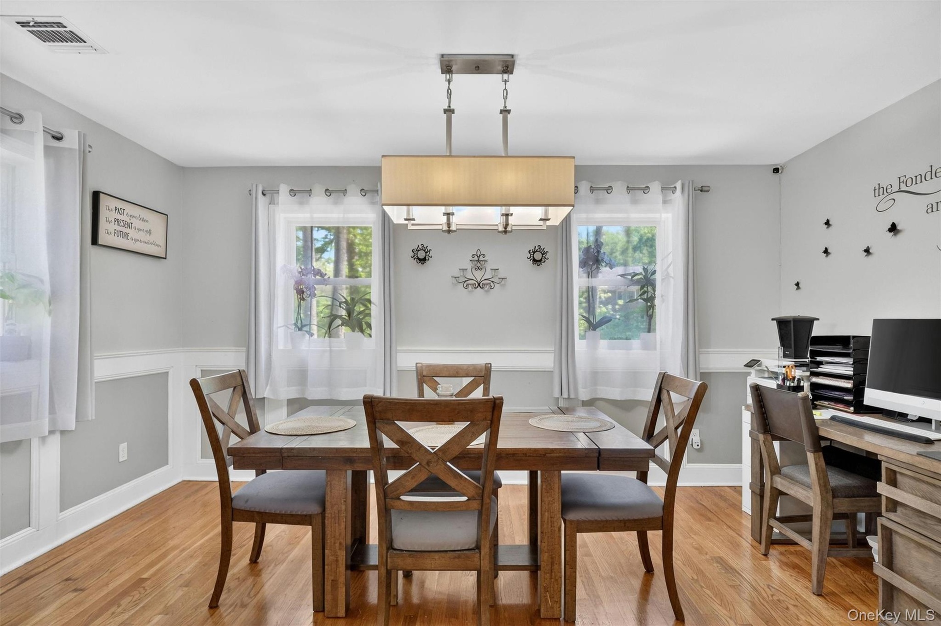 Hardwood flooring, recessed lighting, chair rail molding, multiple windows, and a ceiling-mounted light fixture