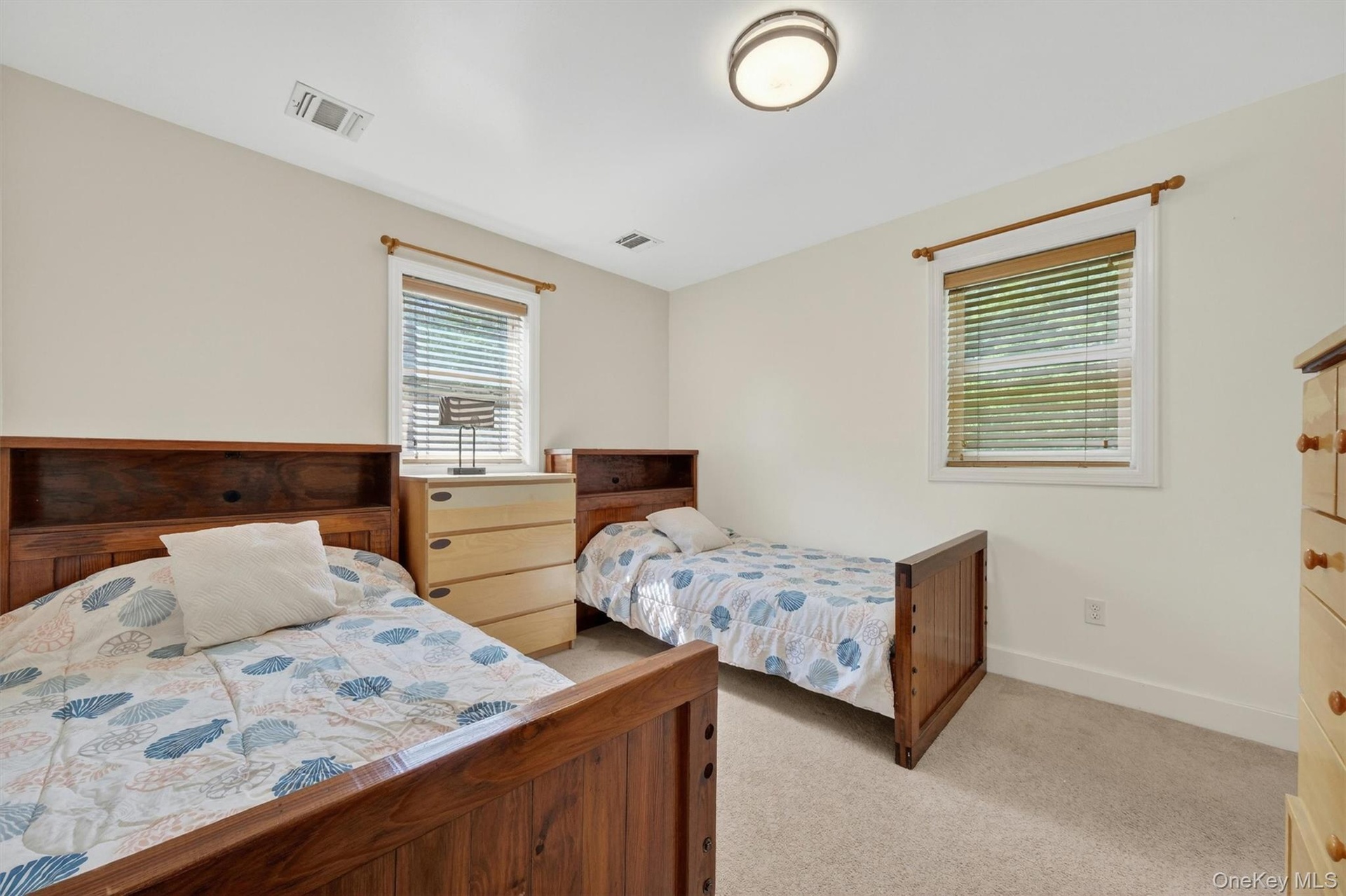 Recessed lighting, light-colored walls, built-in wooden headboards, and carpeted flooring