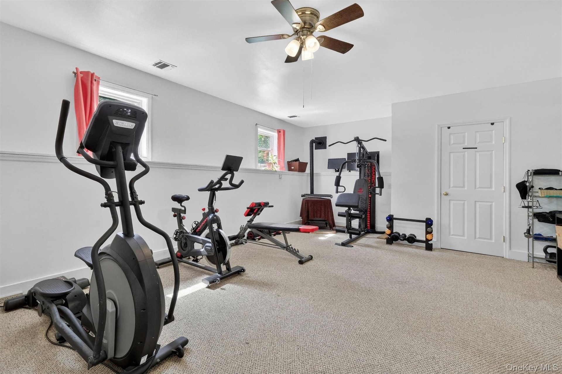 Recessed lighting, ceiling fan, white paneled door, and two windows