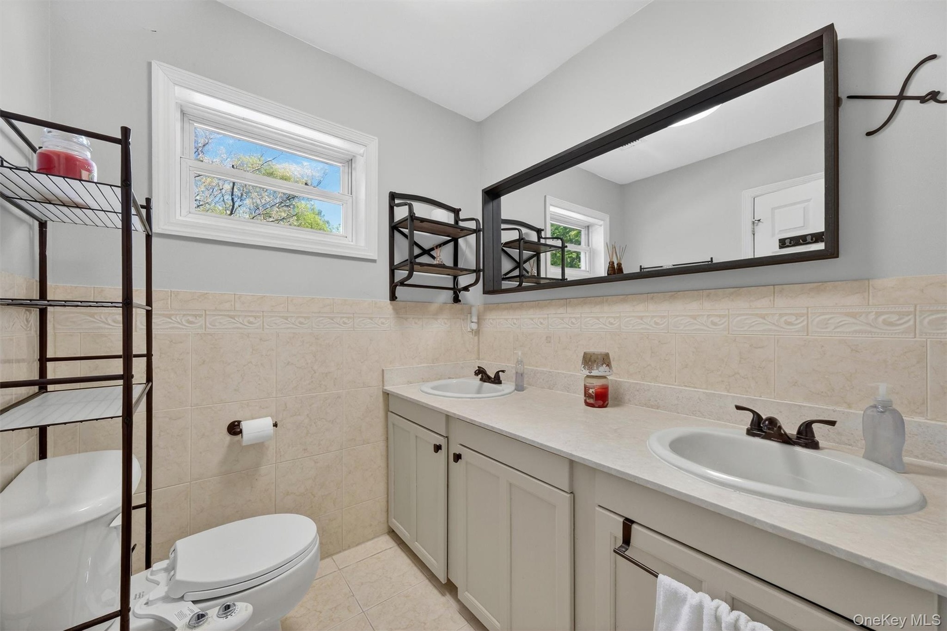 Dual vanity with integrated sinks, framed mirror, and tile backsplash