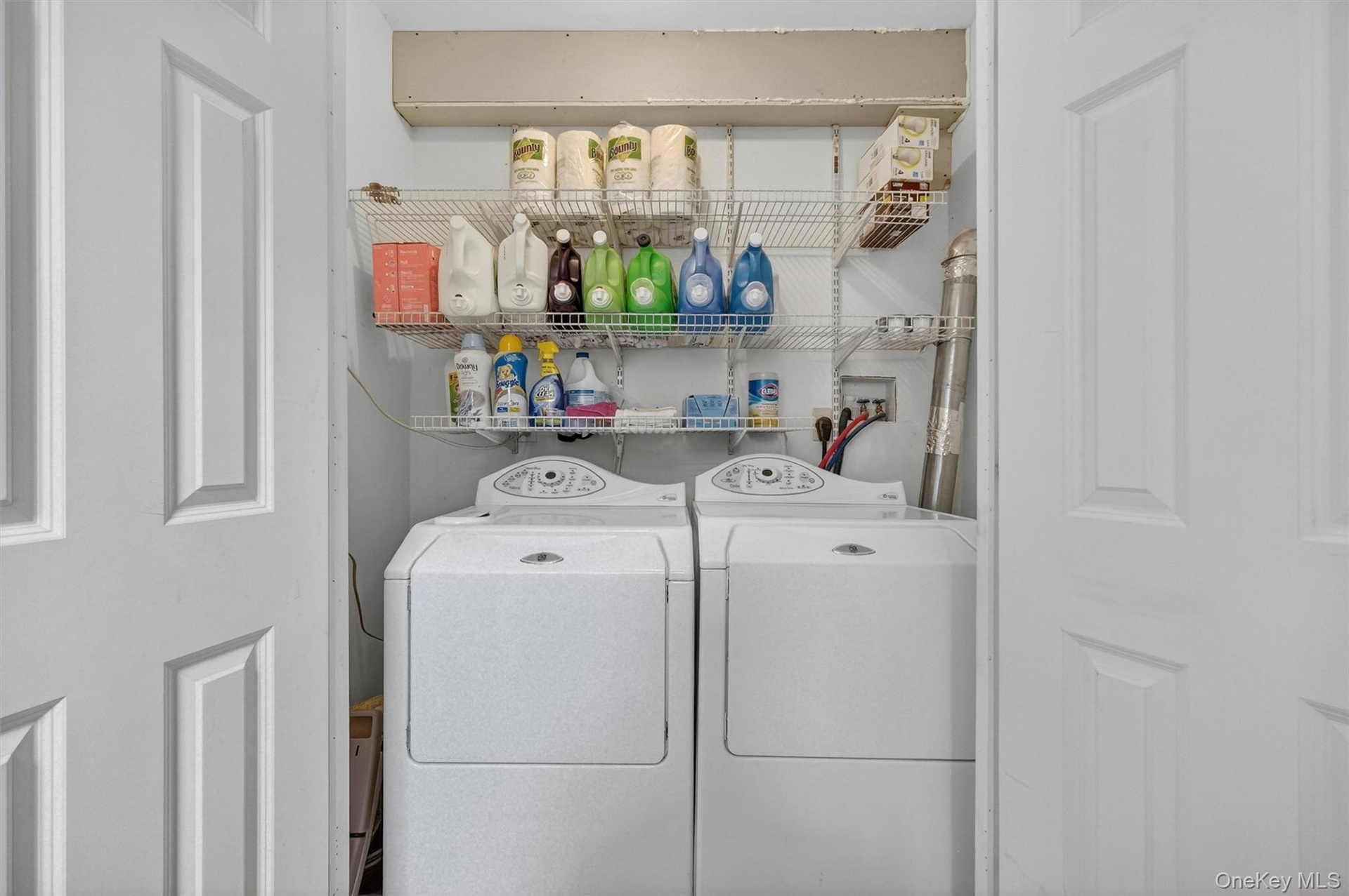 Laundry area with white paneled bifold doors and wire shelving