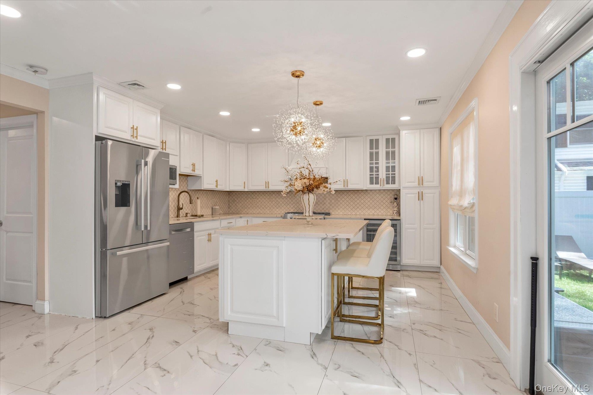 Cooks kitchen featuring white cabinetry, 2023 refrigerator, Bosch Dishwasher, Center island, Quartz Counters, Stainless steel appliances, beverage ref